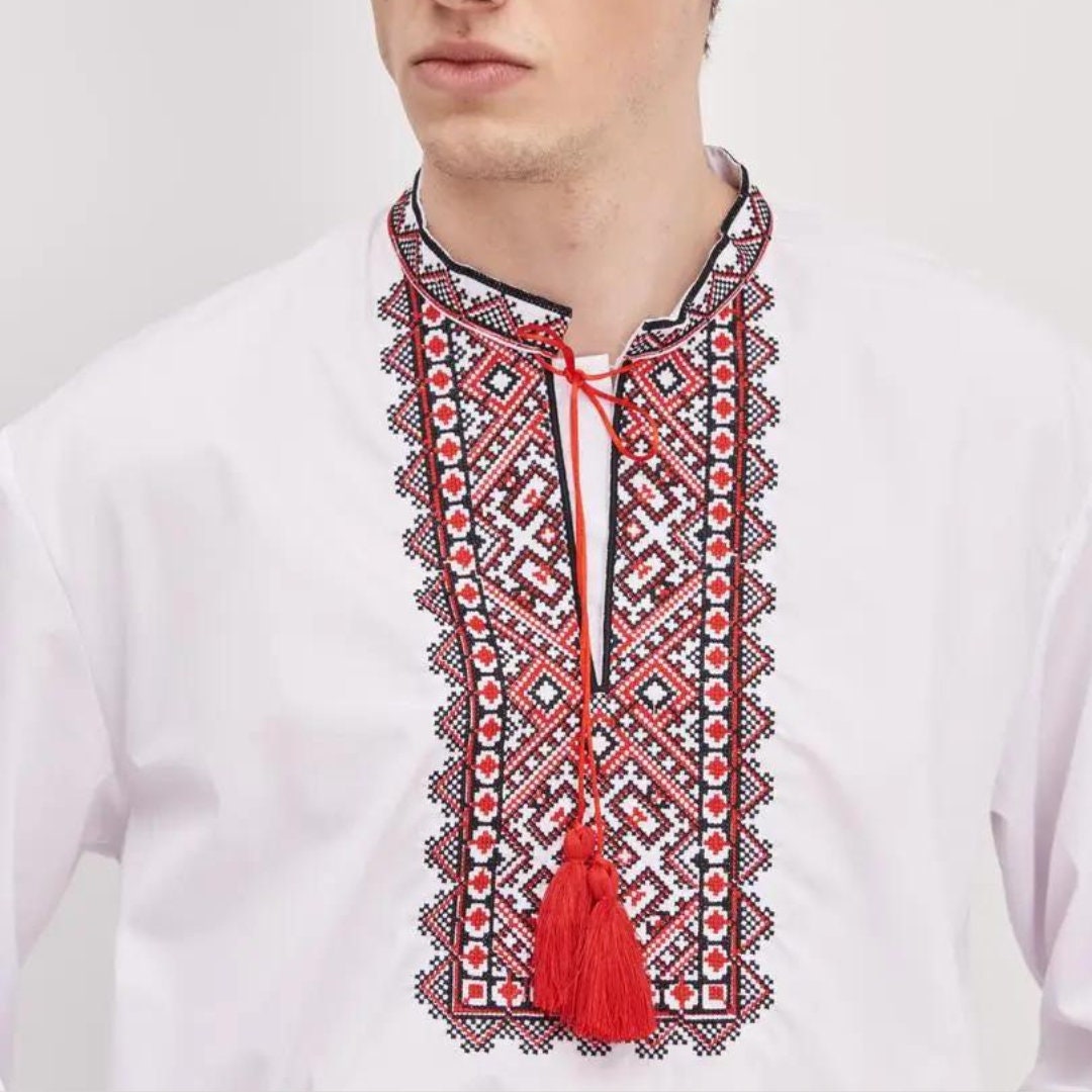 a man wearing a white shirt with a red tassel