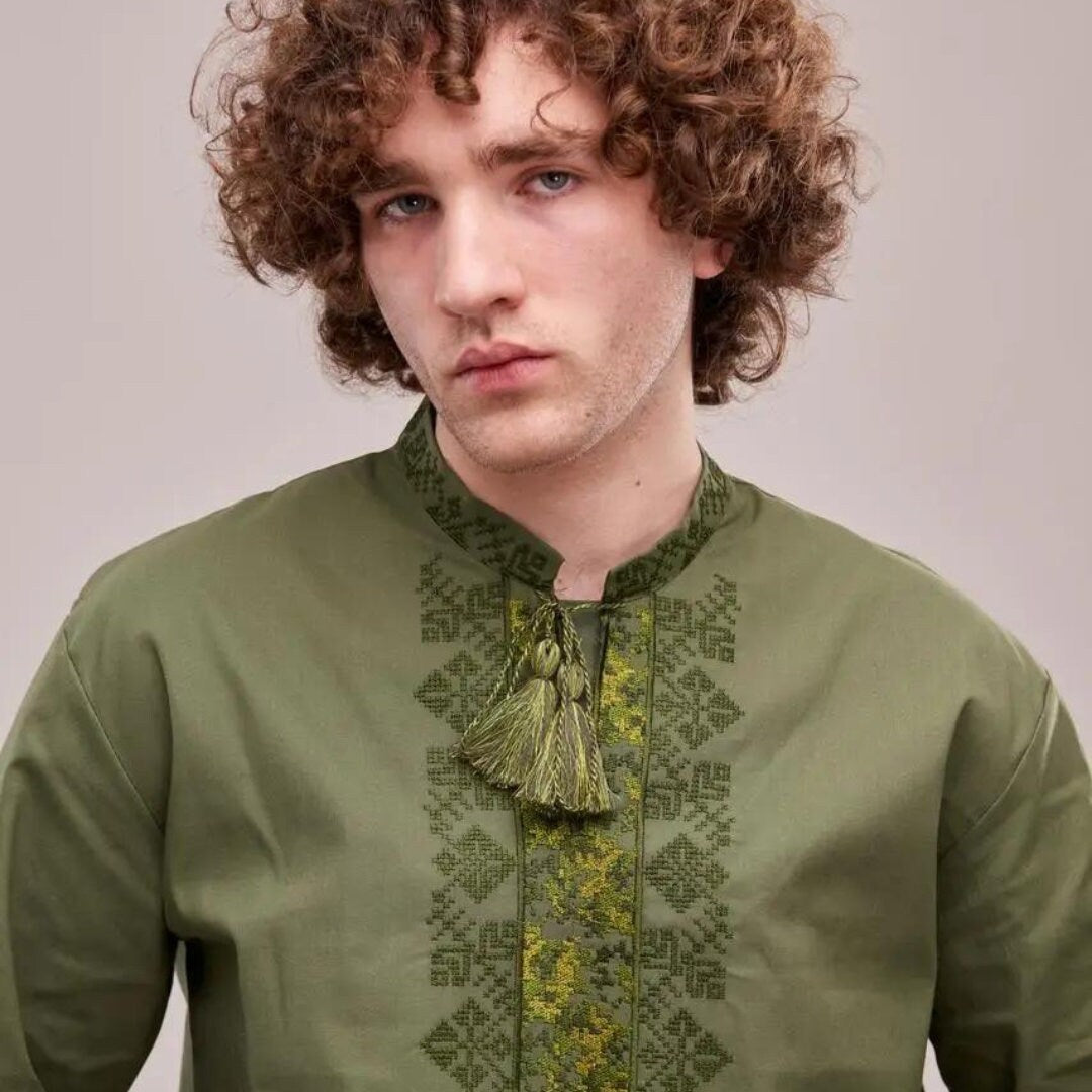 a man with curly hair wearing a green shirt