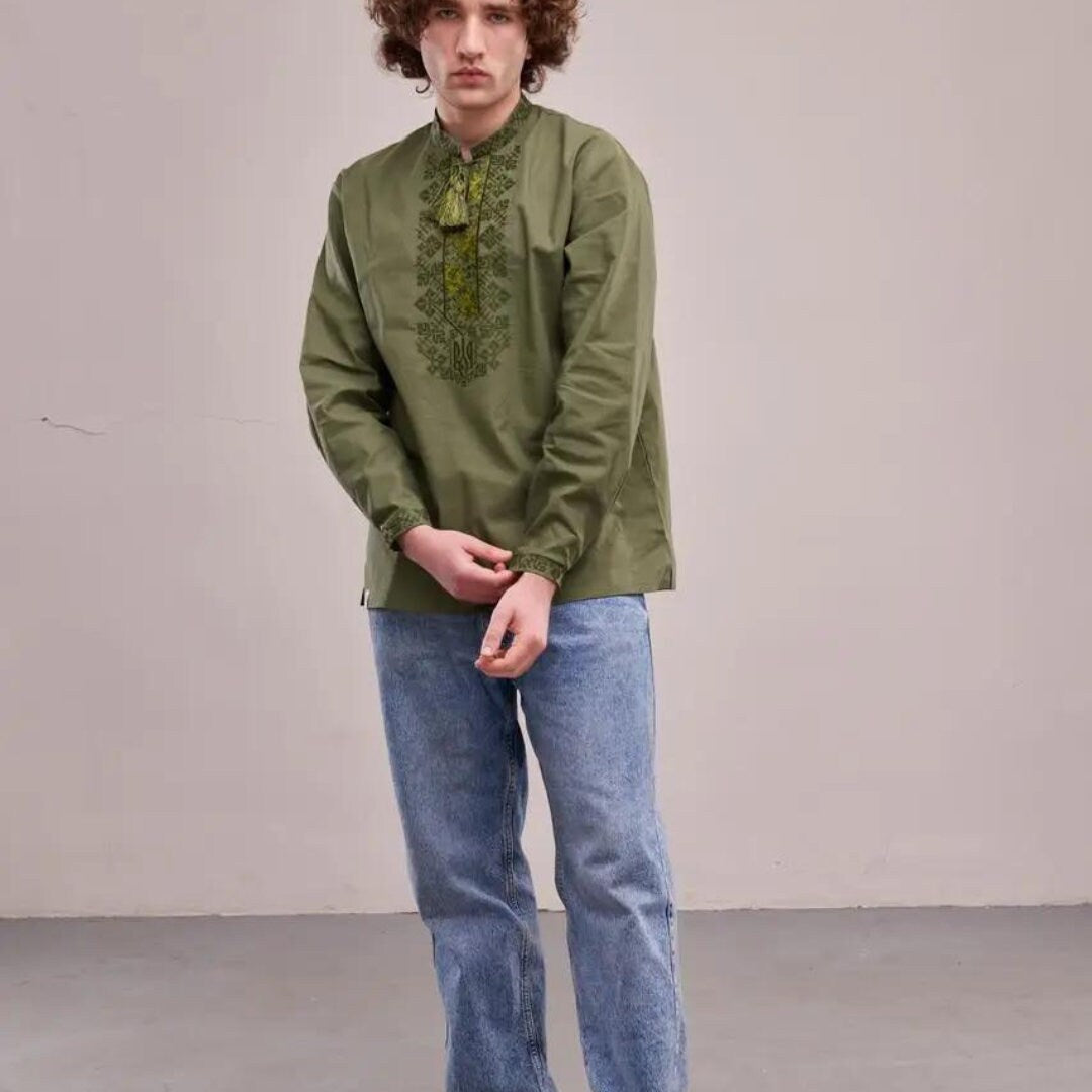 a young man wearing a green shirt and jeans