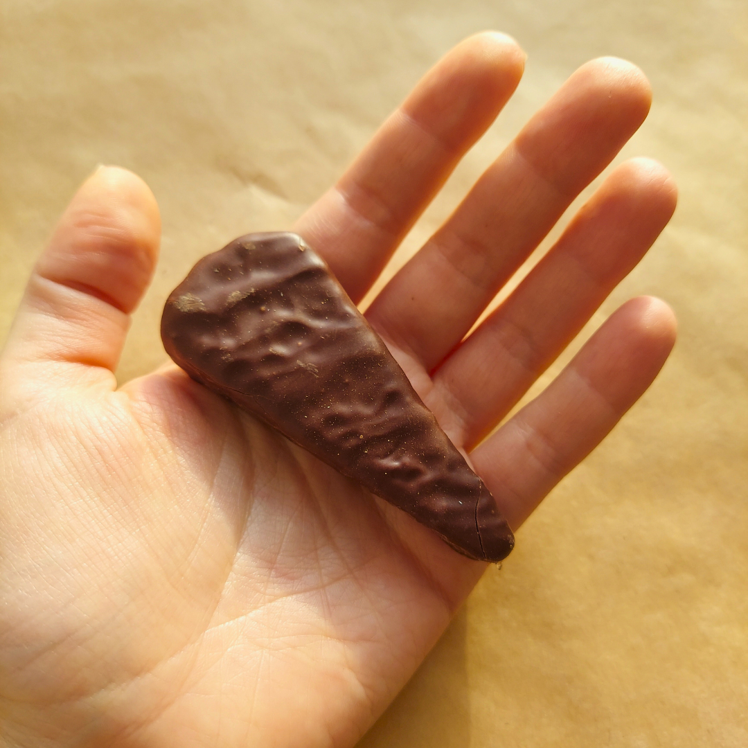 a hand holding a piece of chocolate in it&#39;s palm