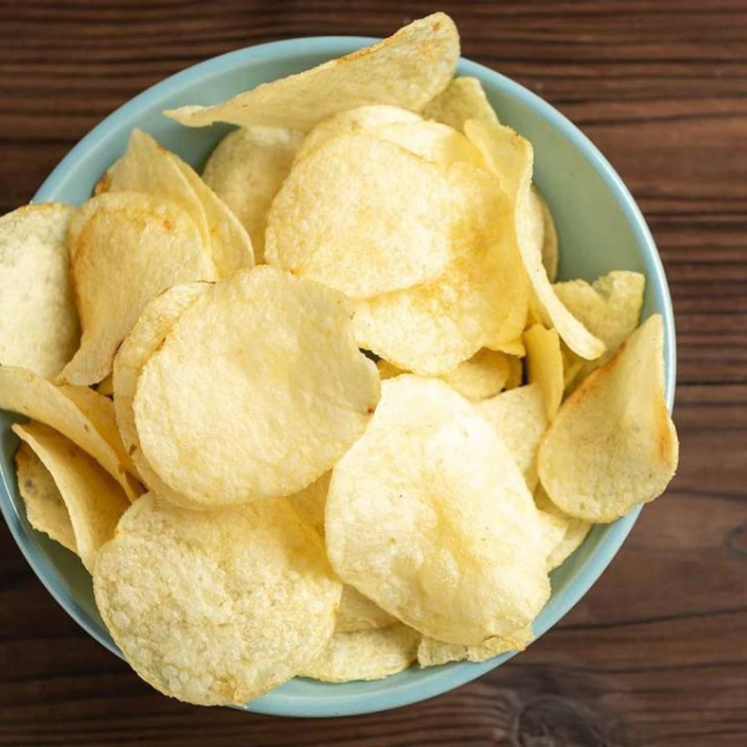 a bowl of potato chips on a wooden table