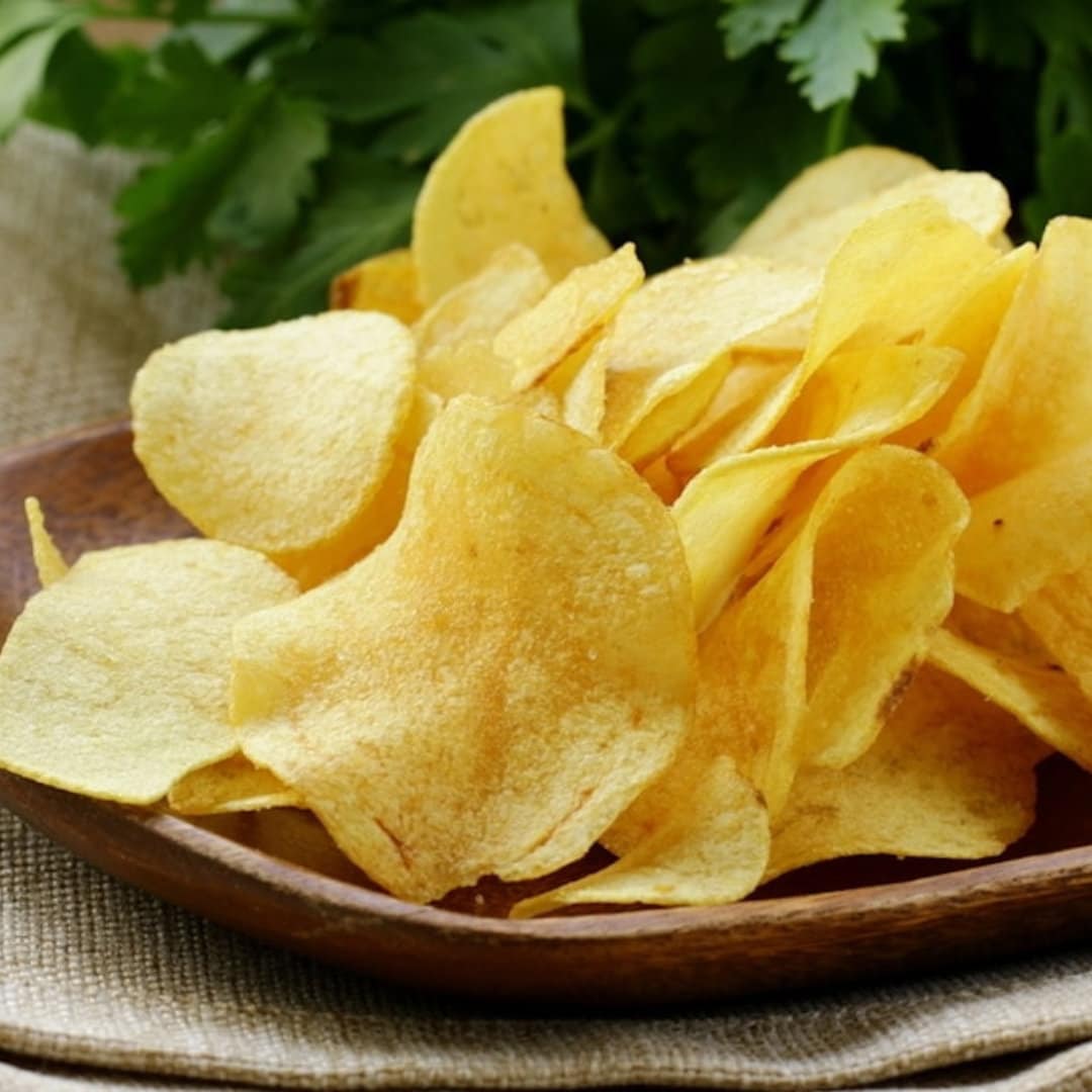 a wooden bowl filled with chips on top of a table