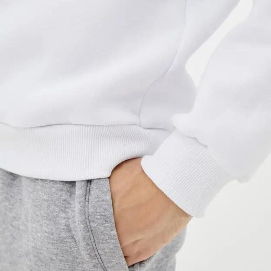 a person wearing a white sweatshirt and grey sweatpants