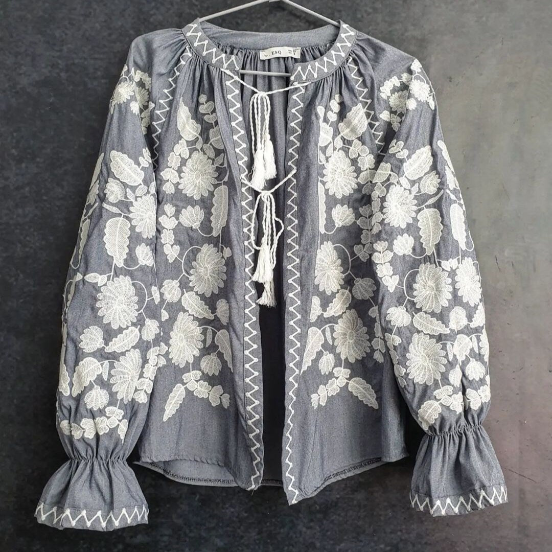 a gray blouse with white flowers on it