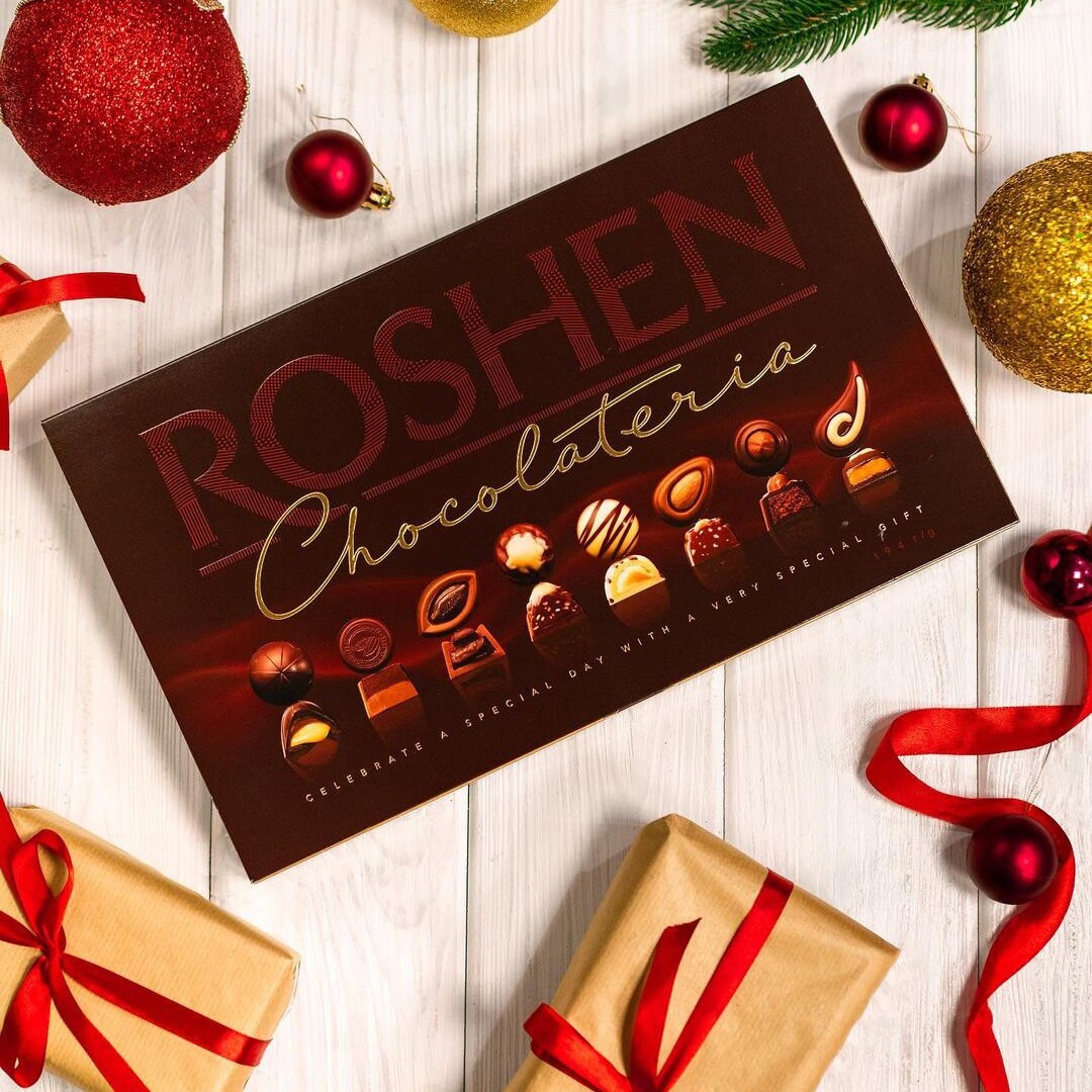 a box of roshen chocolates surrounded by christmas decorations