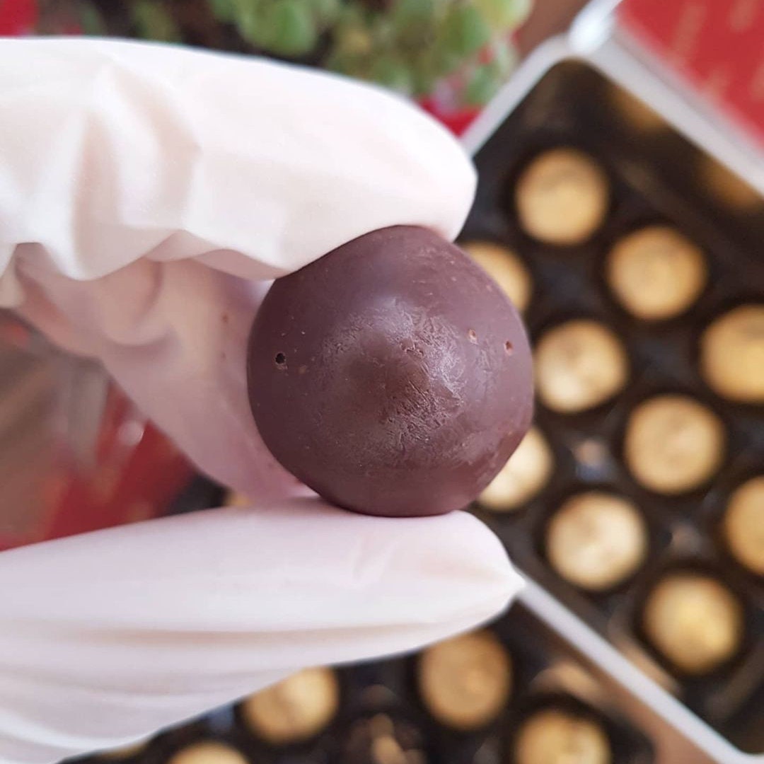 a person holding a chocolate ball in their hand