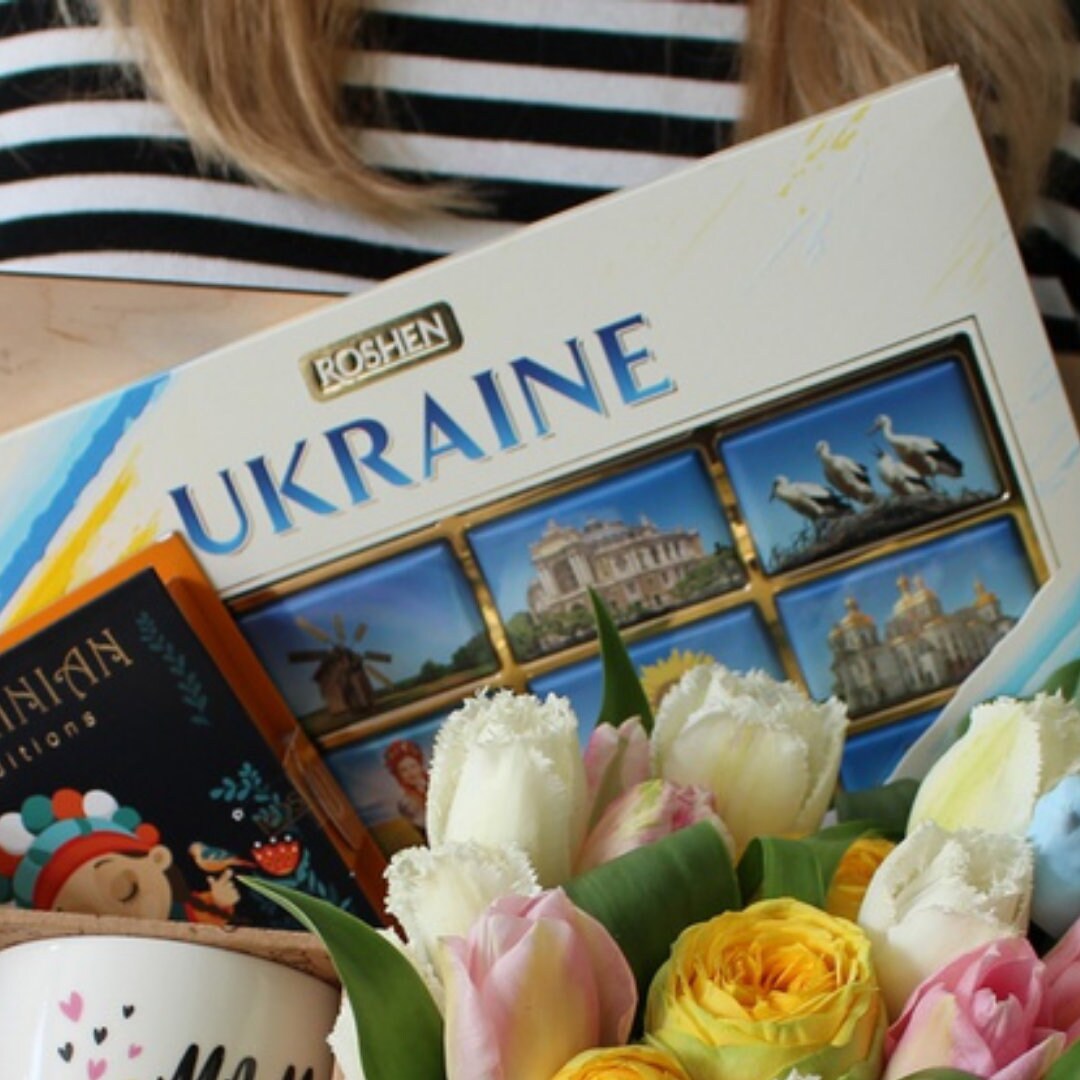 a woman holding a book and a bouquet of flowers