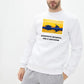 a man wearing a white sweatshirt with a picture of a plane on it