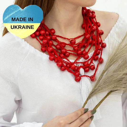 a woman wearing a red necklace with beads