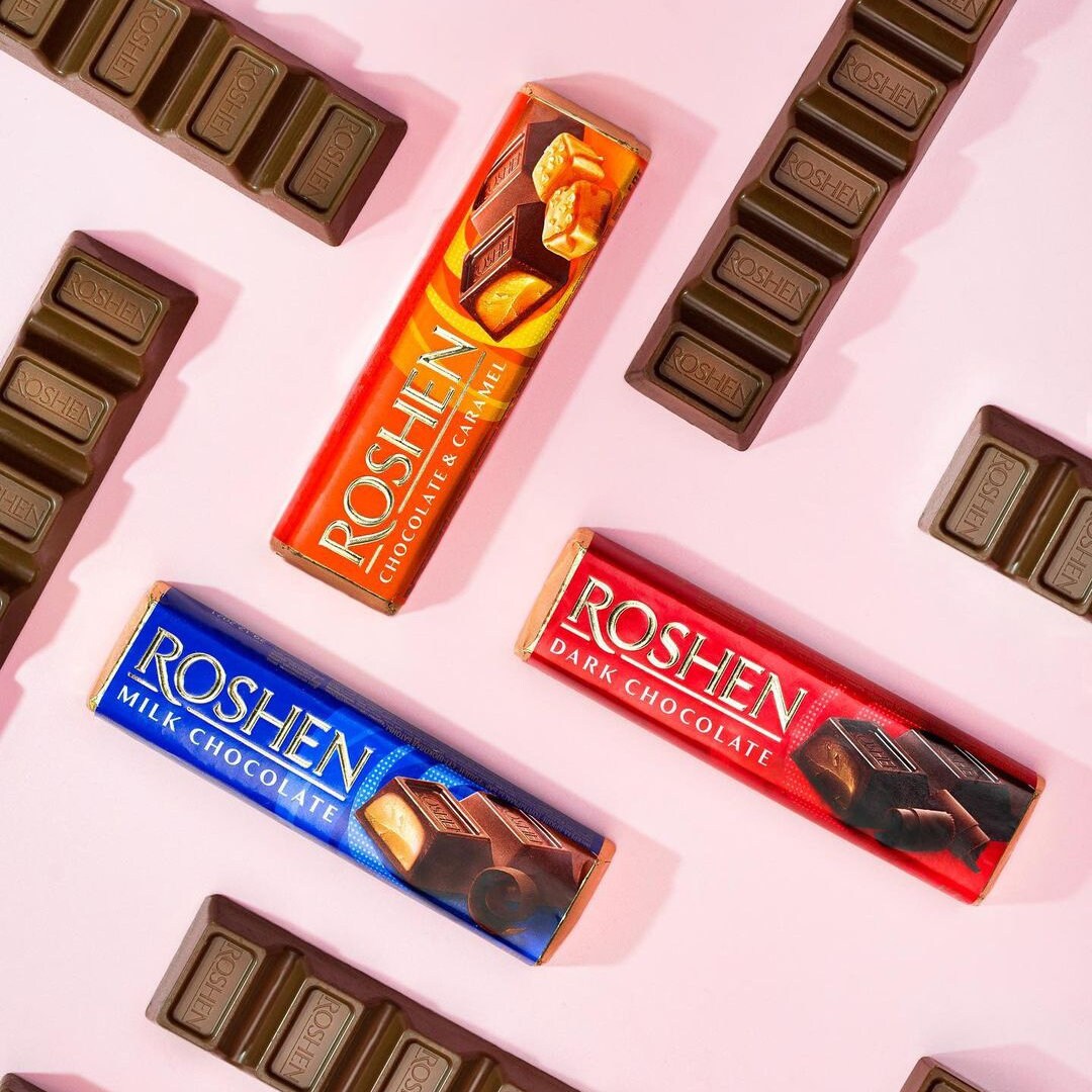 chocolate bars are lined up on a pink surface