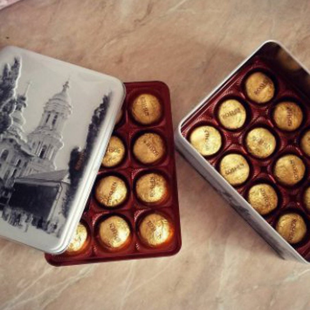 a couple of tins filled with chocolates on top of a table