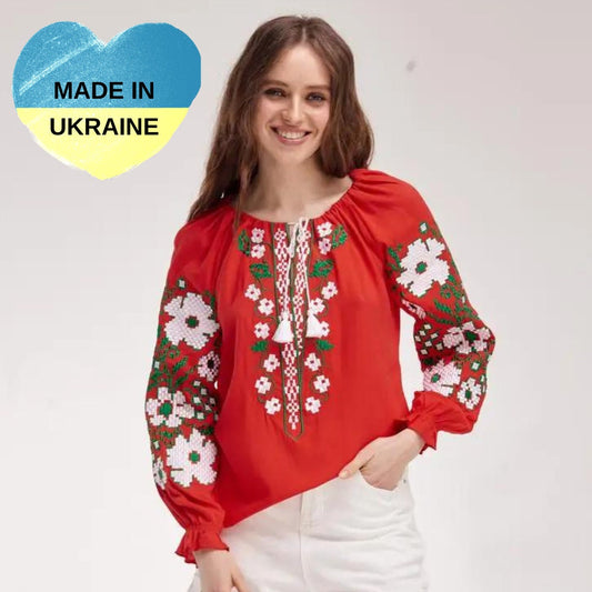 a woman wearing a red blouse with flowers on it