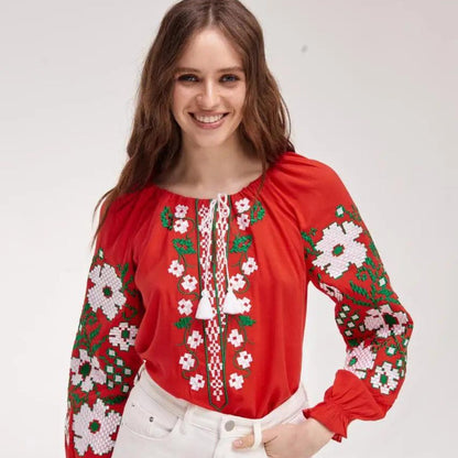 a woman wearing a red blouse and white pants