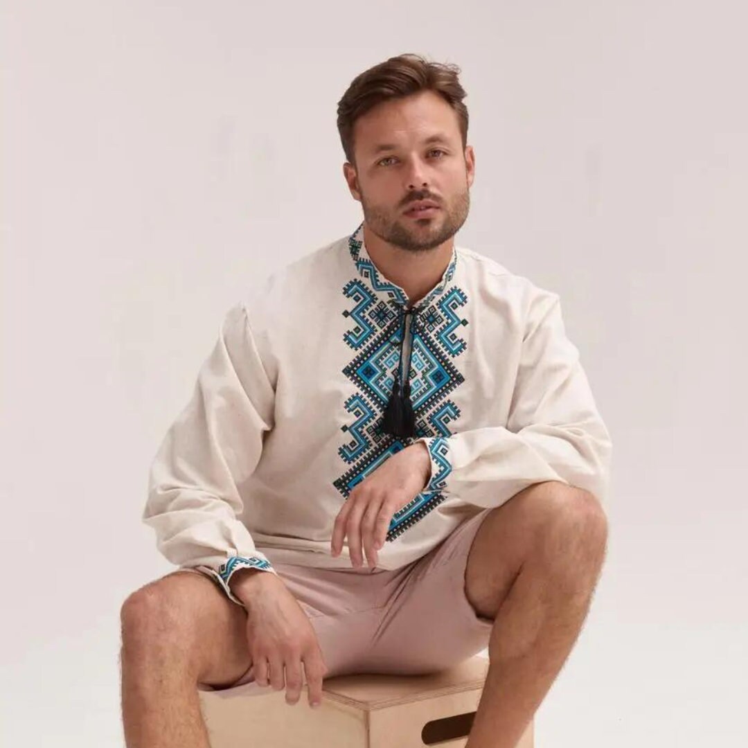 a man in a shirt and tie sitting on a box