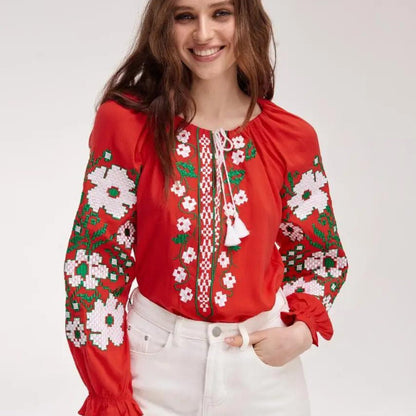 a woman wearing a red blouse and white pants