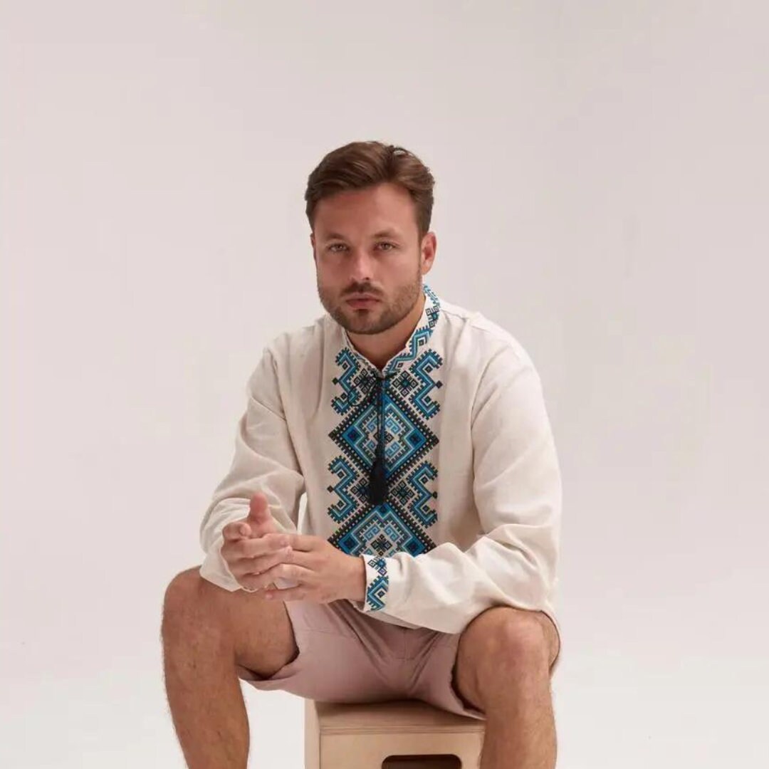 a man sitting on top of a box wearing a shirt and tie