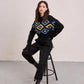 a woman sitting on a stool wearing a sweater