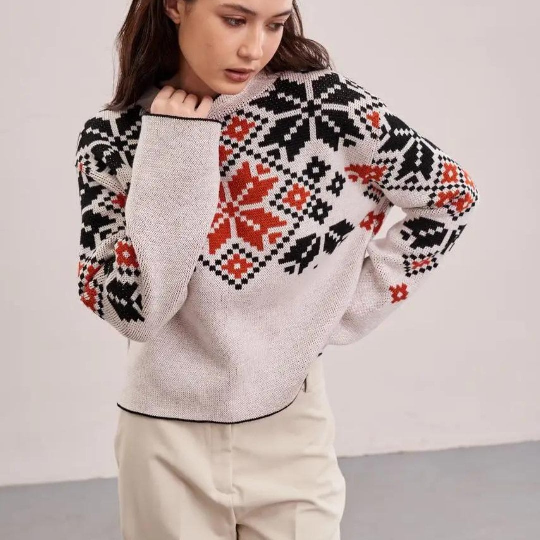 a woman wearing a sweater with a pattern on it